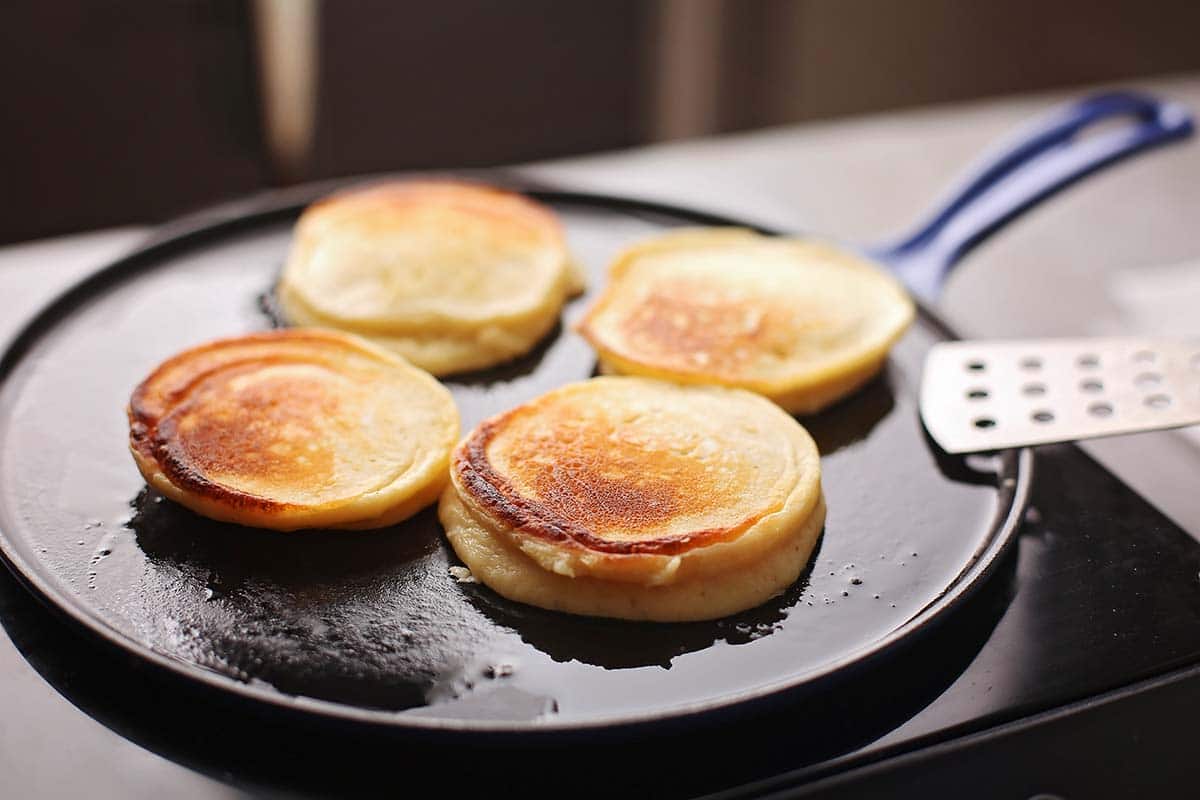 cast iron pan with small-sized pancakes