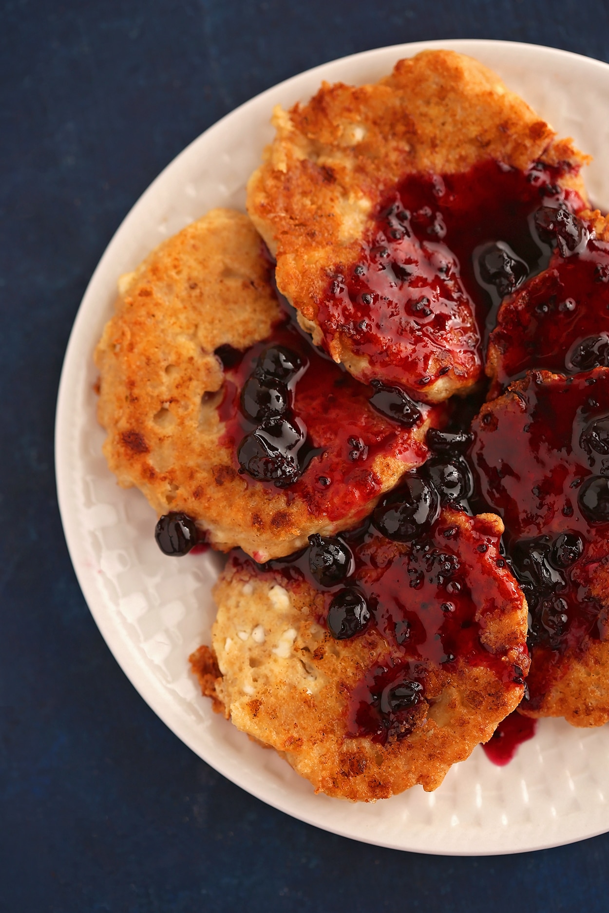 pancakes on a white plate topped with blueberries jam