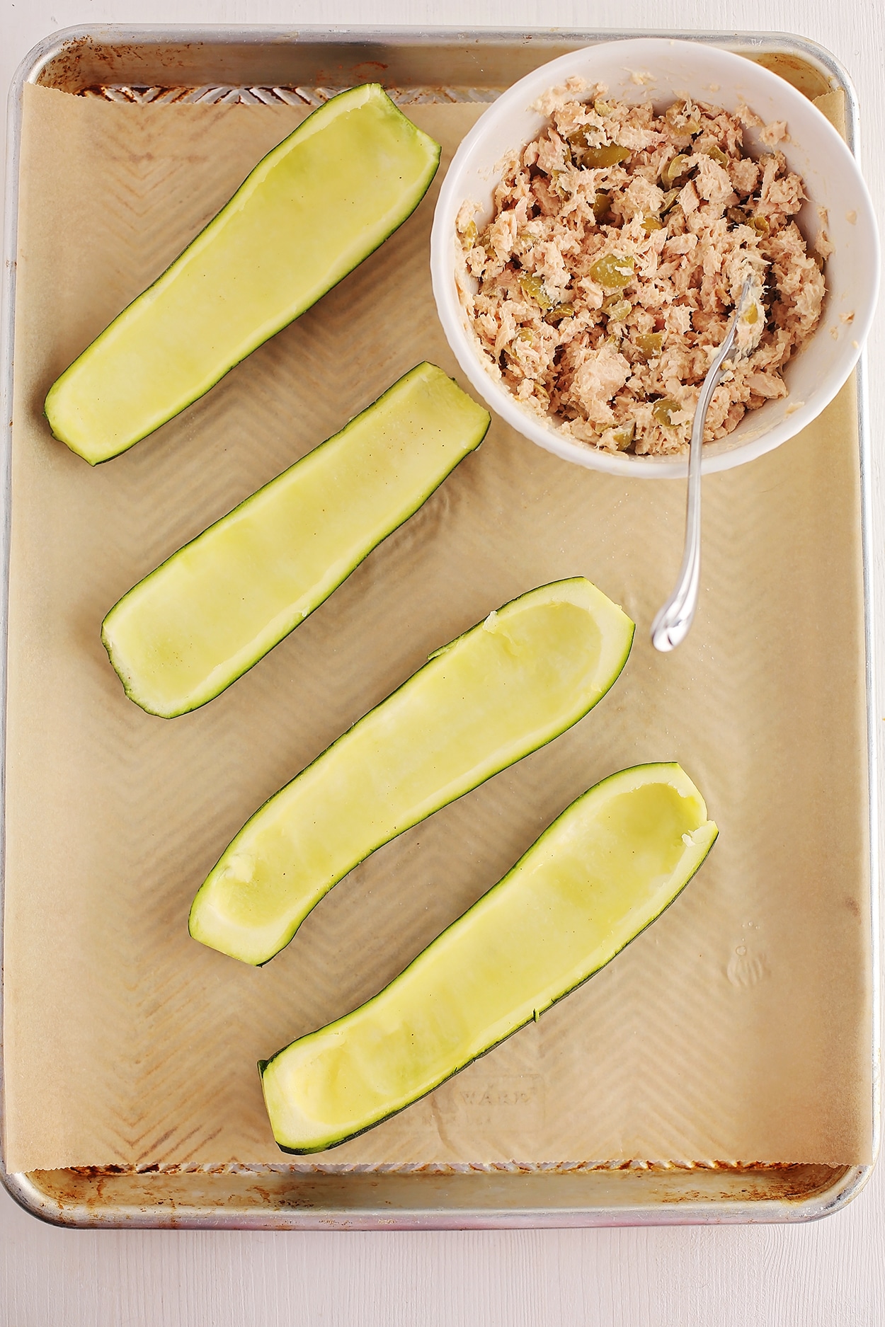 zucchini with scooped out inside ready to be filled with tuna