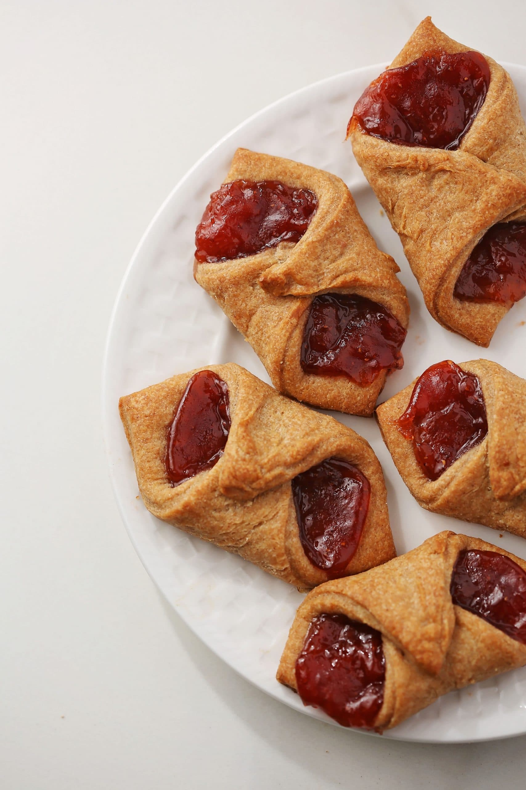 cookies with strawberry jam on a white plate