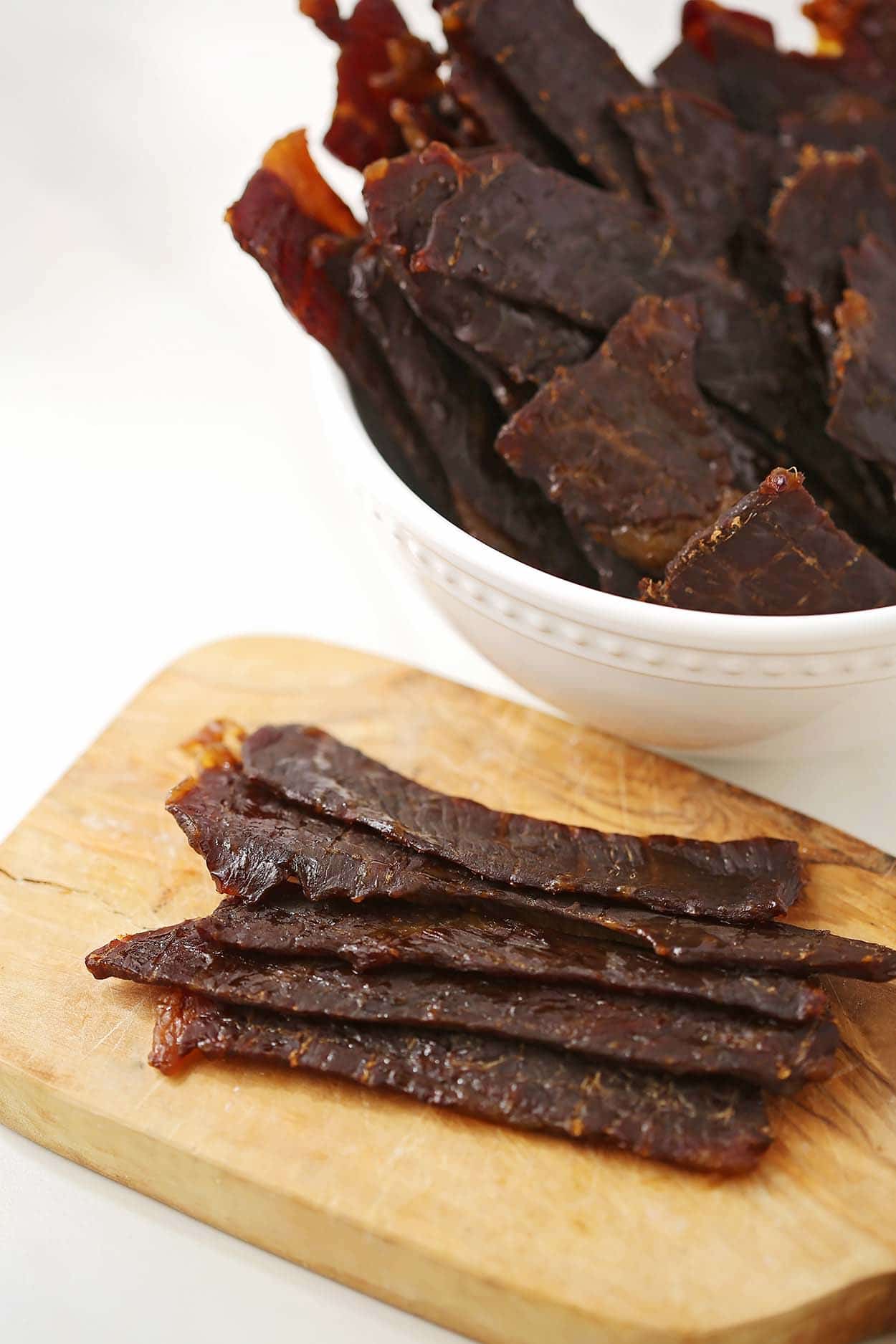 homemade beef jerky laying on wooden cutting board