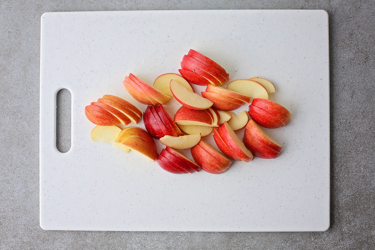 sliced apples on a white cutting board