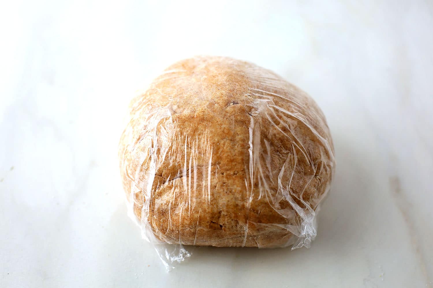 ball of dough in a plastic wrap