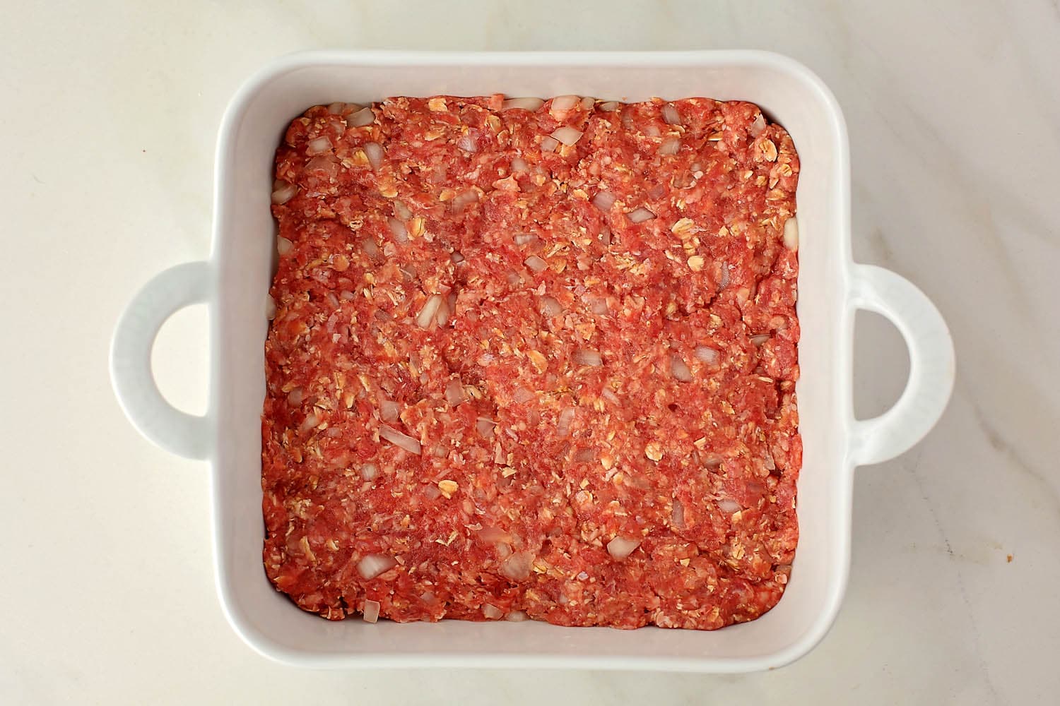 baking dish with layer of ground beef