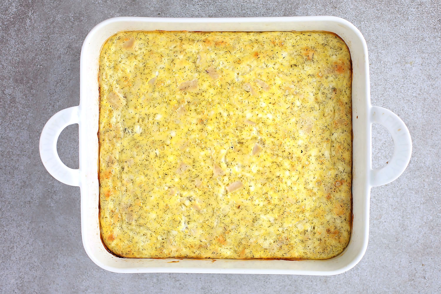 white baking dish with freshly baked quiche with cheese