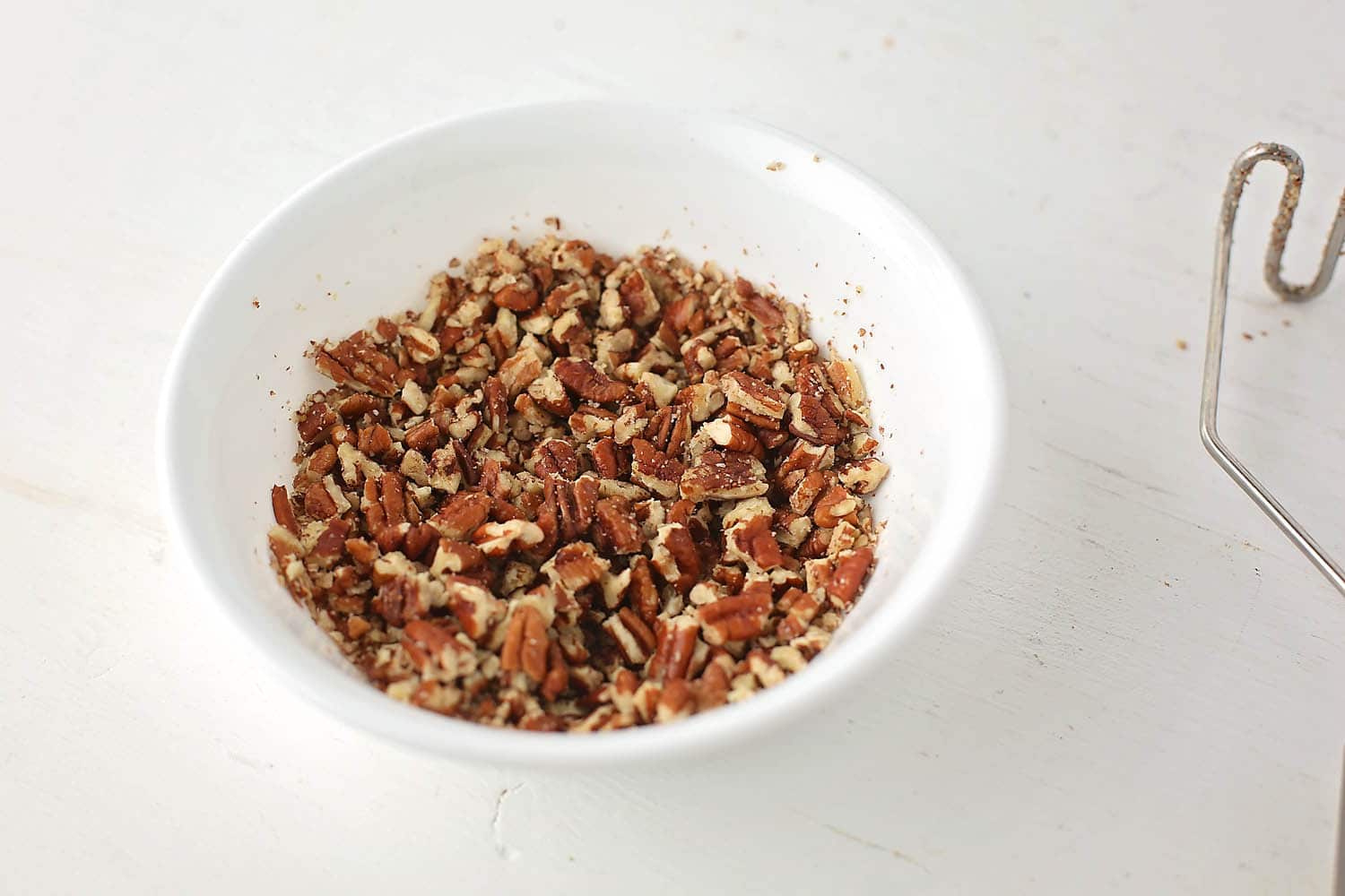 white bowl with crushed pecans