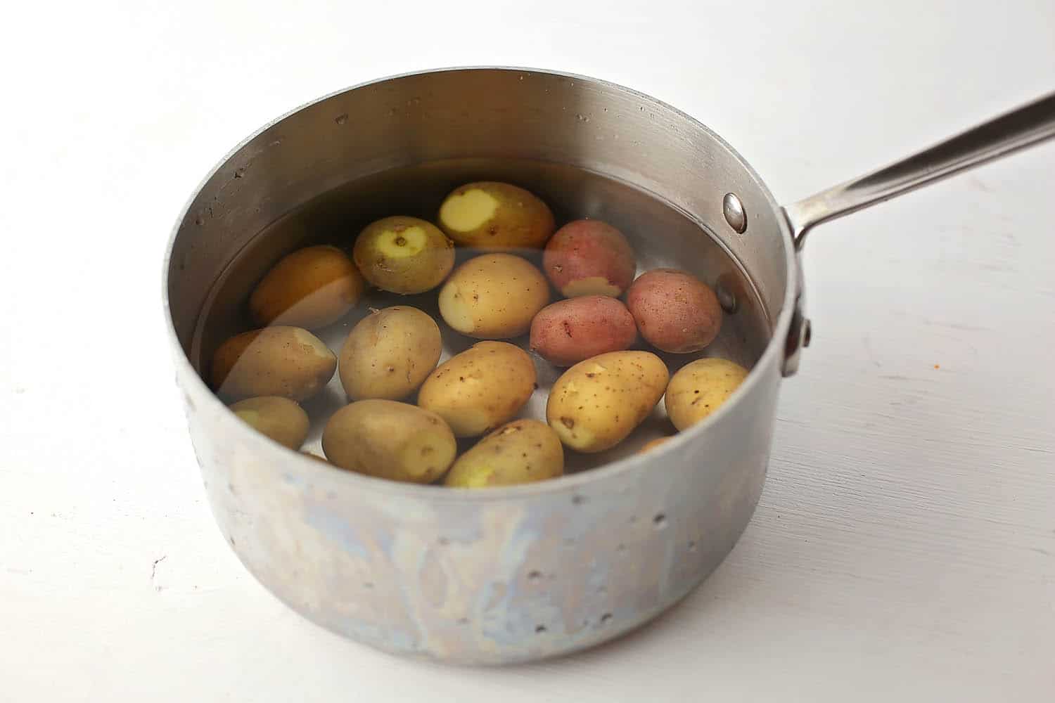 small saucepan with potatoes and water inside