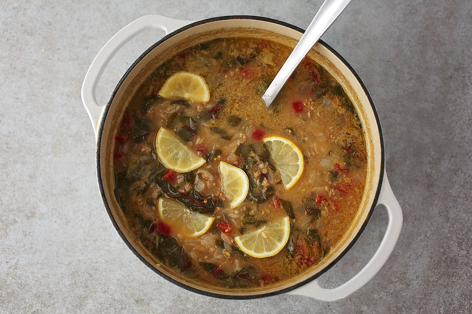 large pot with soup decorated with lemon slices on top