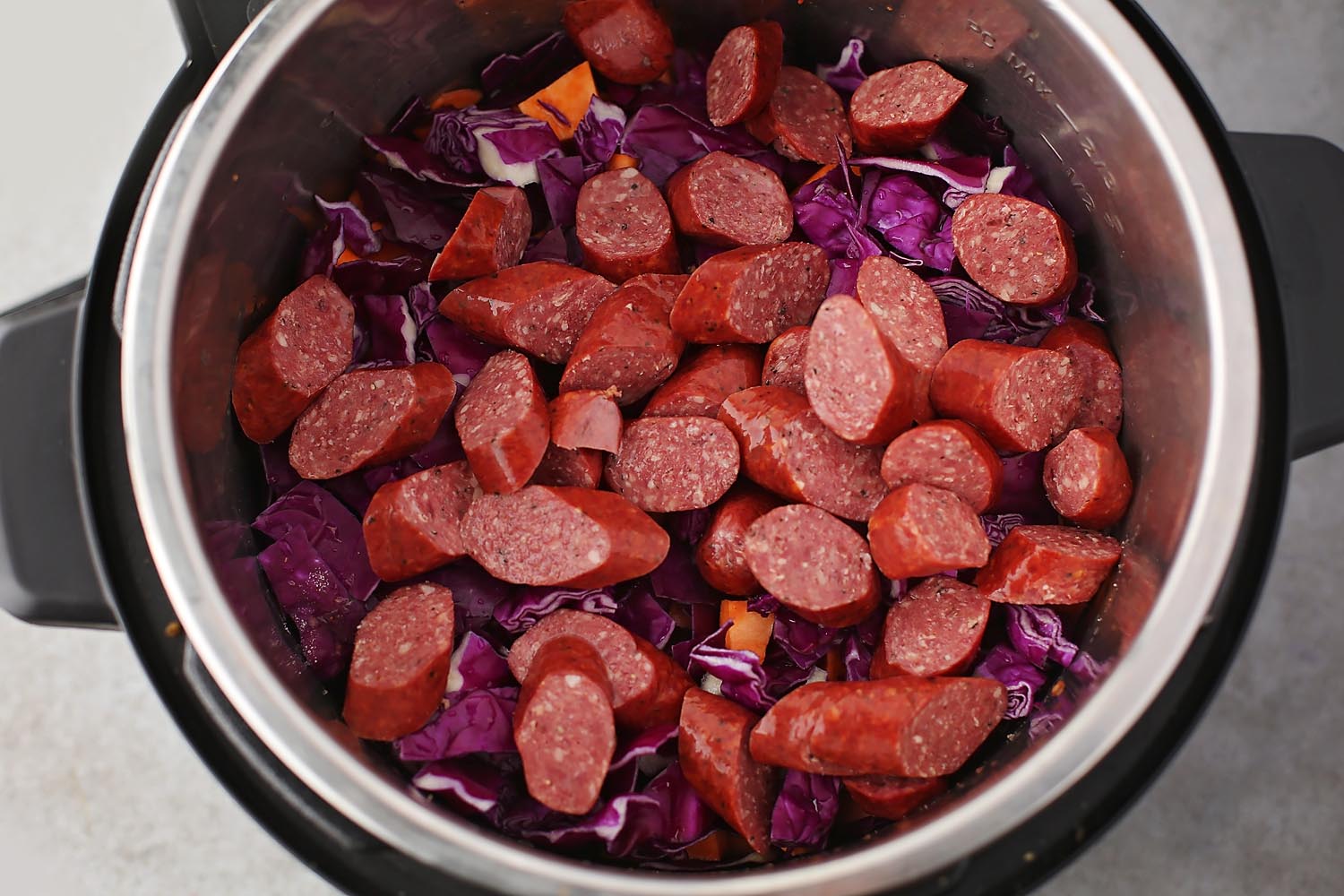 an instant pot filled with sausage and cabbage