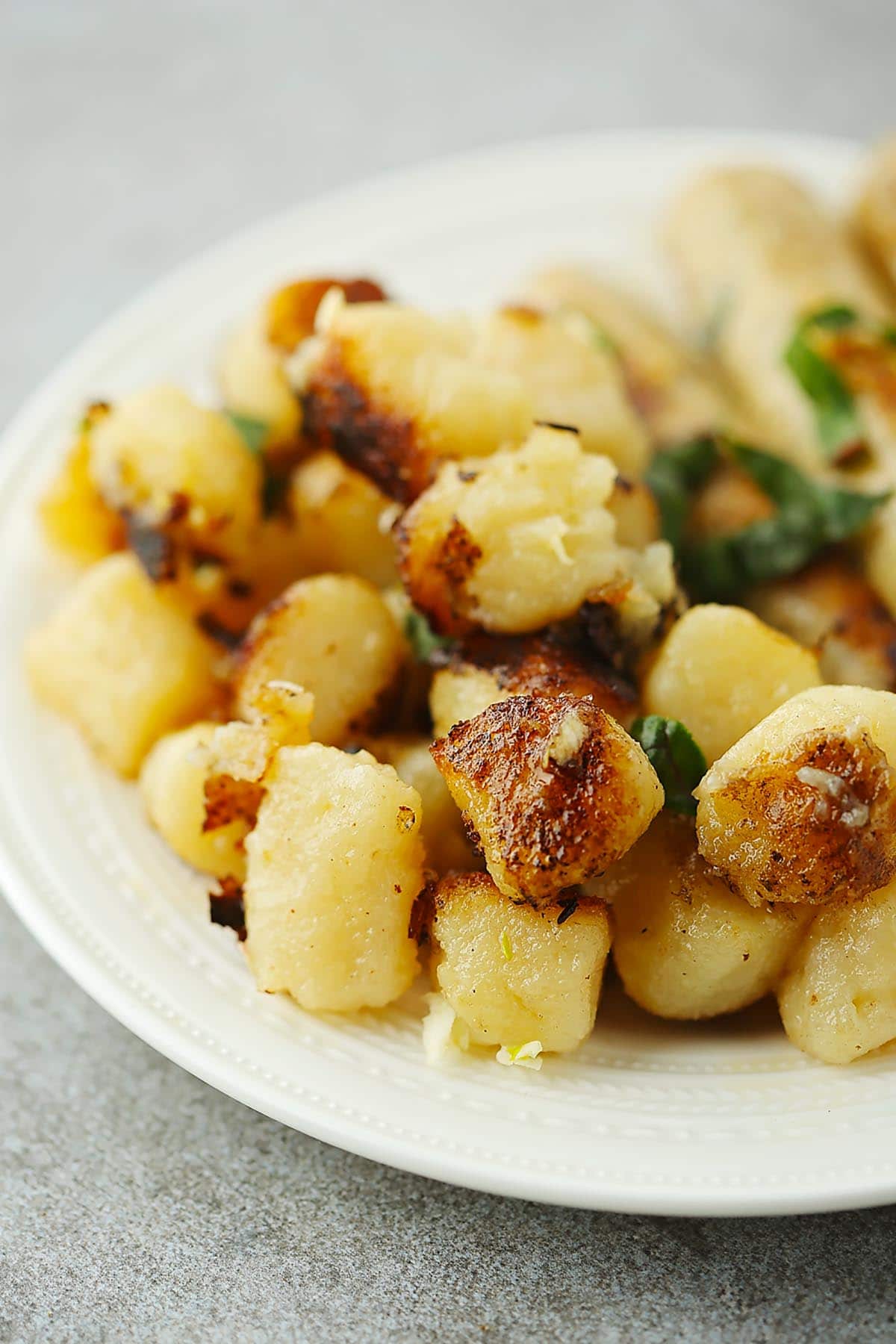 white plate filled with fried gnocchi