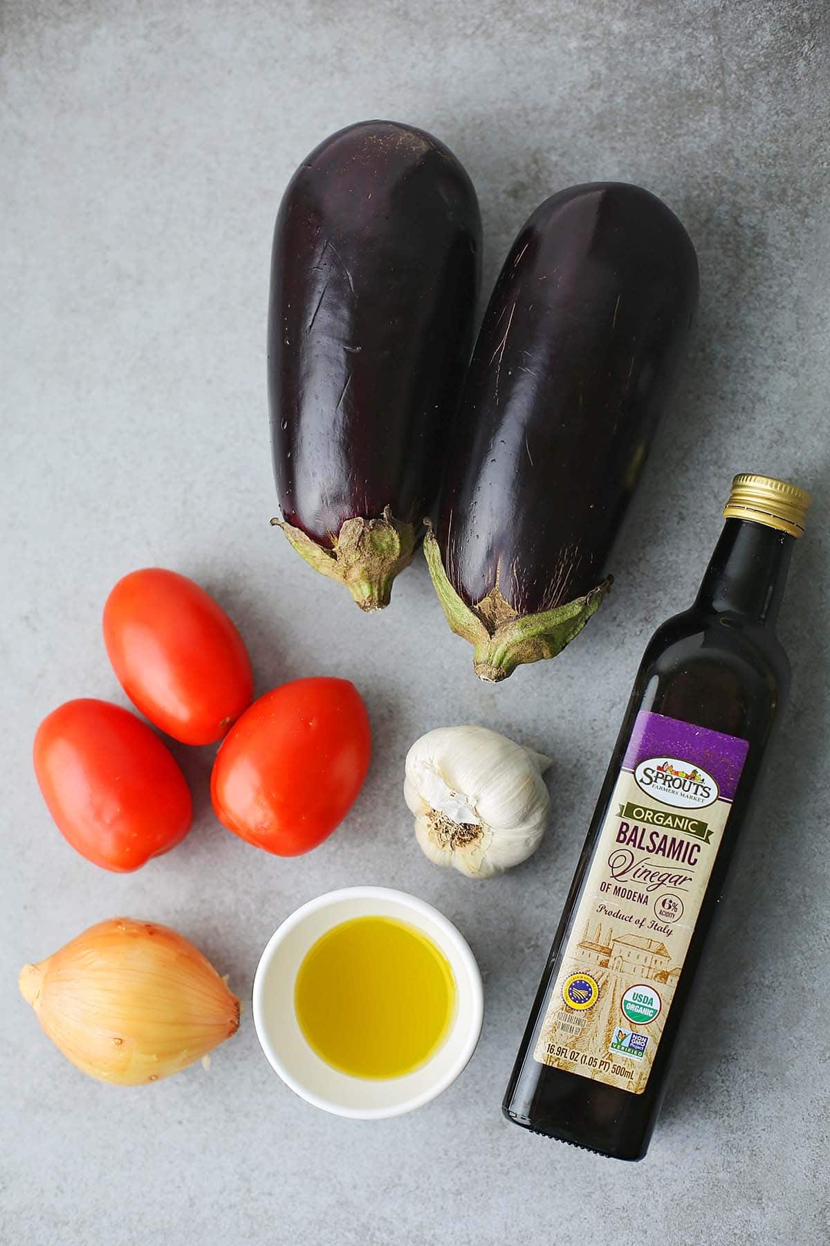 ingredients to make ikra eggplant spread: eggplants, tomatoes, onion, garlic, olive oil and balsamic vinegar.