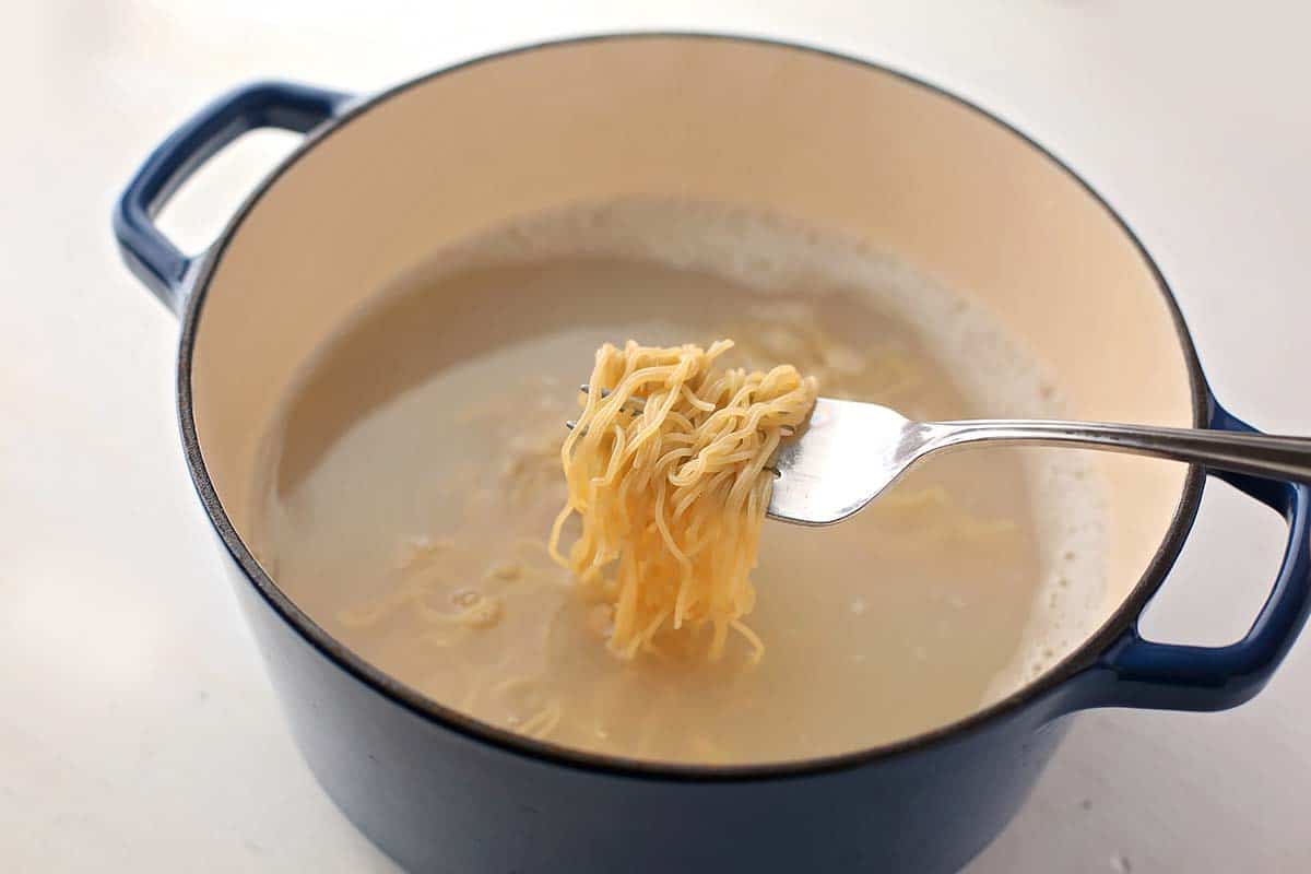 pot filled with water and cooked ramen noodles