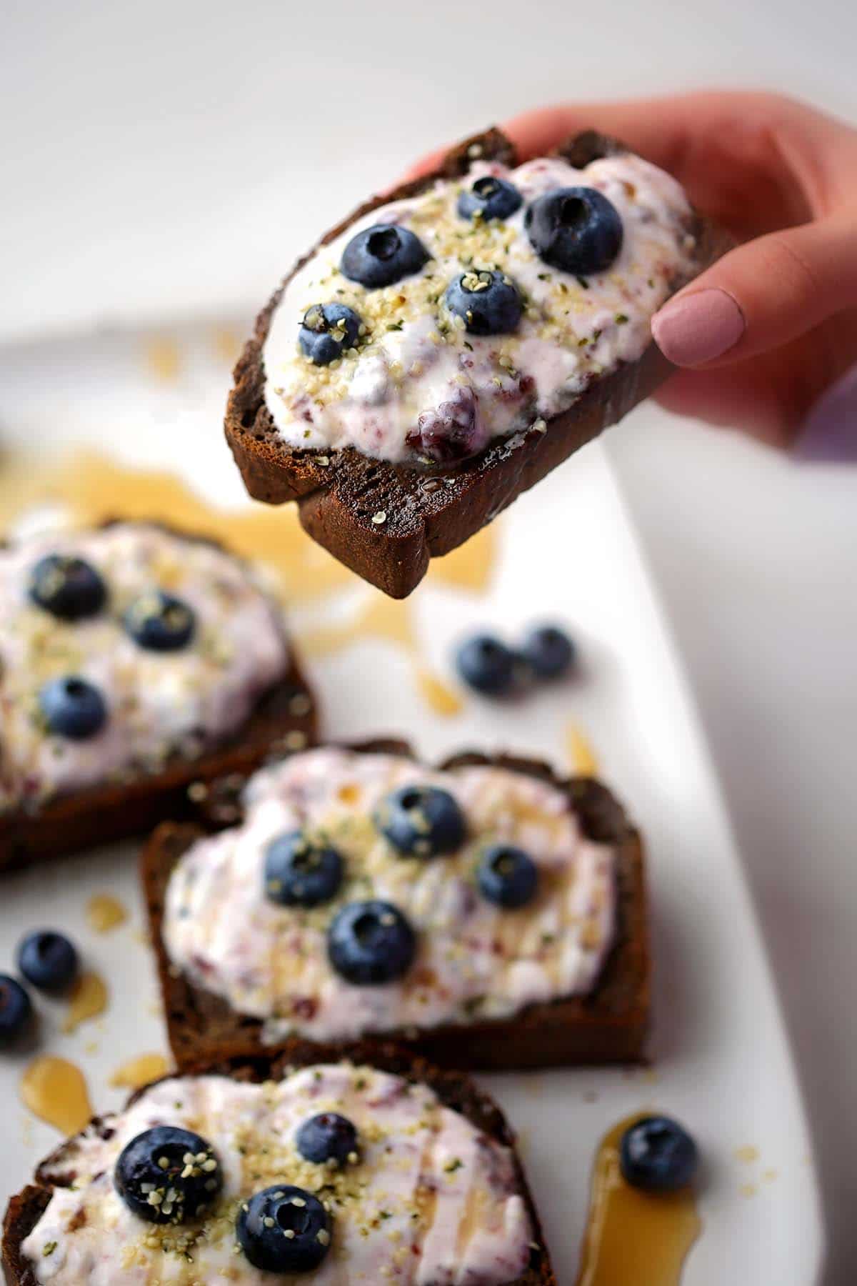 close up shot of the banana bread slice with yogurt and blueberries