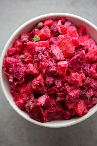 white bowl filled with bright pink salad with beets