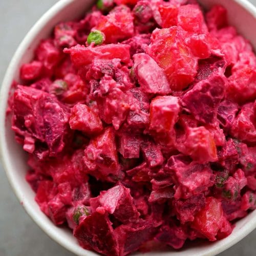 white bowl filled with bright pink salad with beets