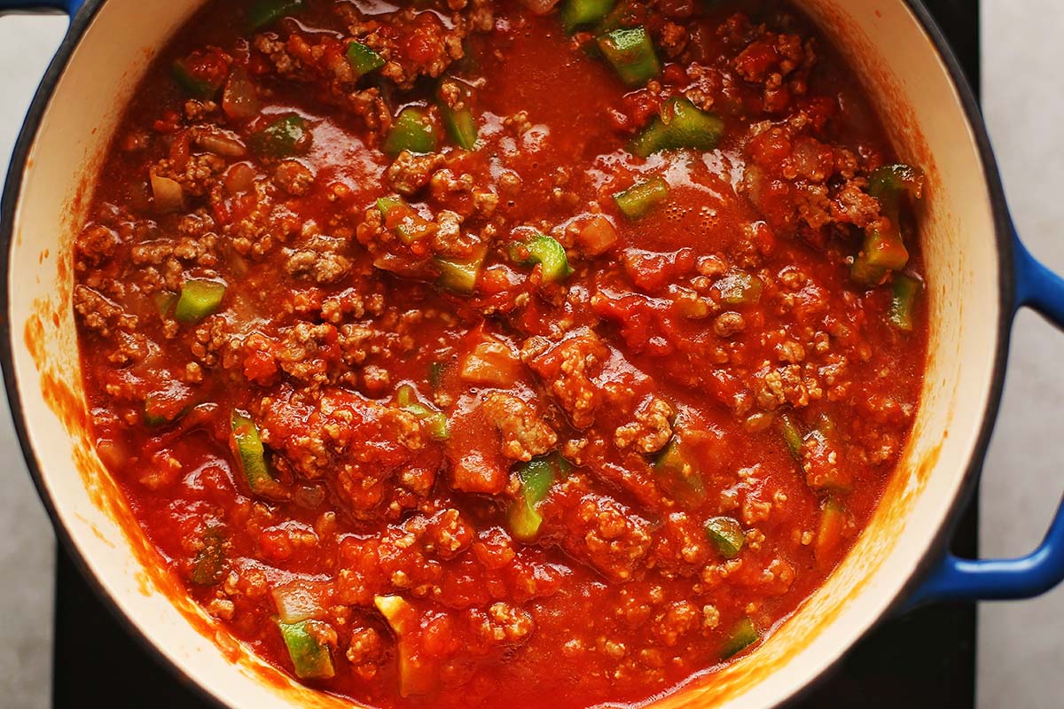 ducth oven with cooked ground meat and red sauce