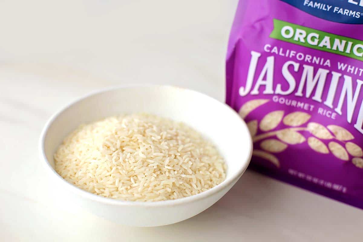 white bowl filled with rice and purple package labeled Jasmine rice
