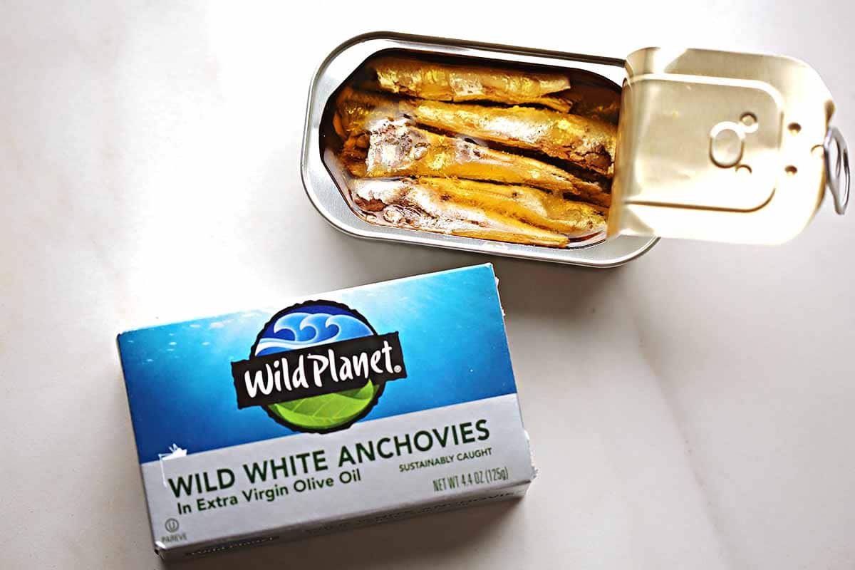 open tin with small anchovy fish packed in oil