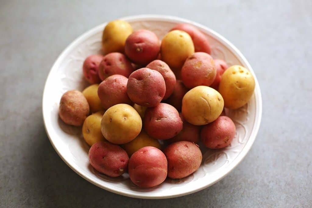 white bowl filled with uncooked baby potatoes