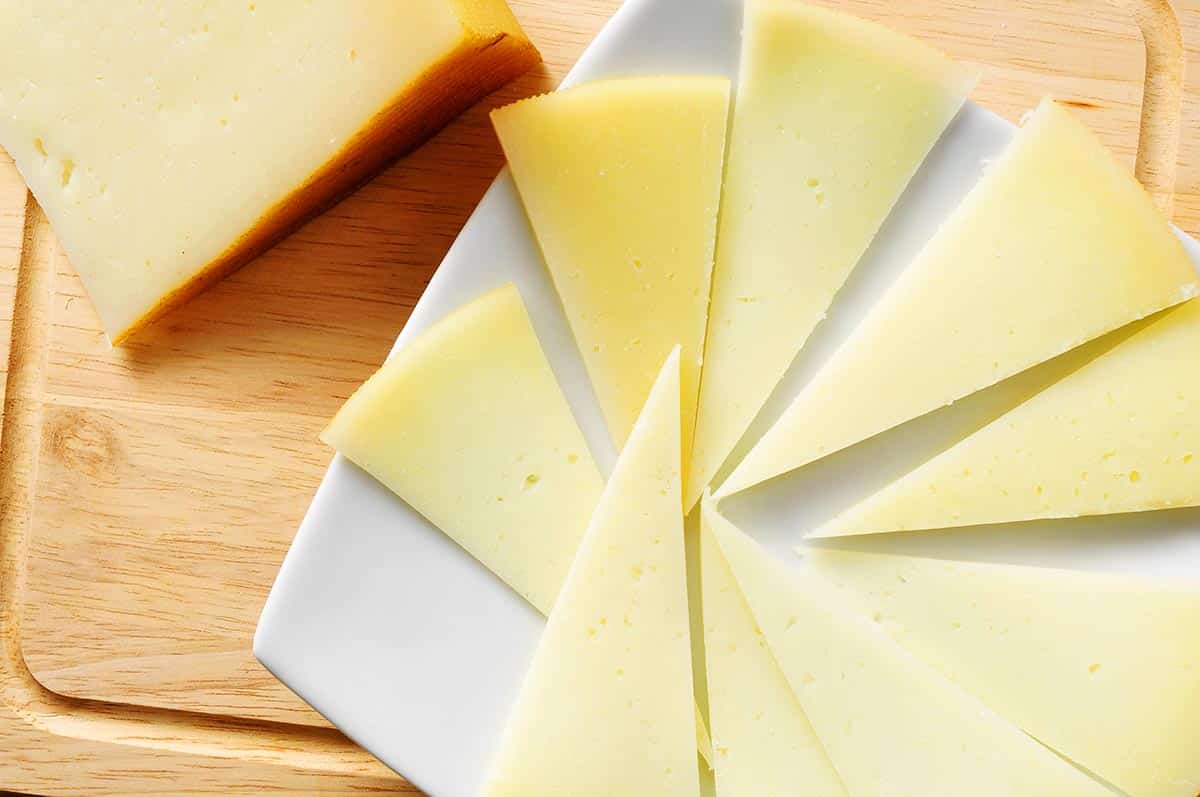 cutting board with sliced manchego cheese