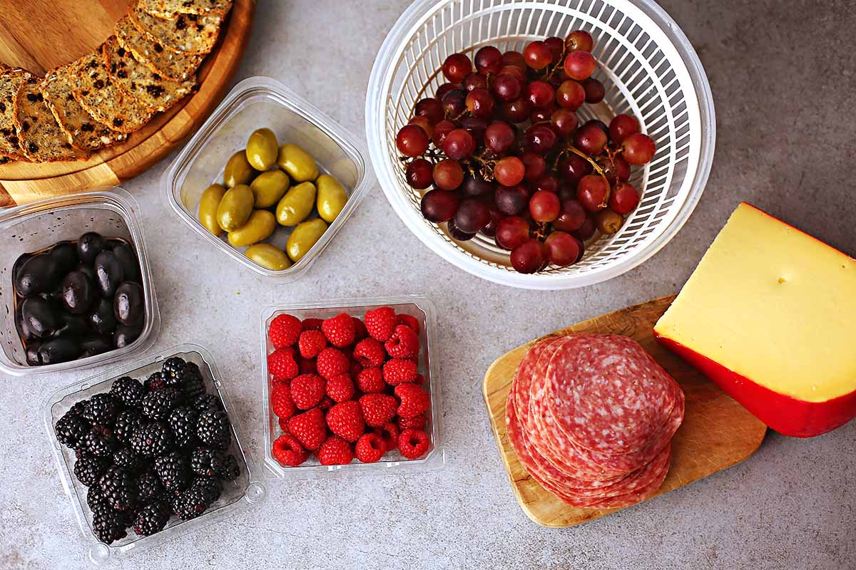 ingredients to make Small charcuterie board with fresh berries, cheese, salami