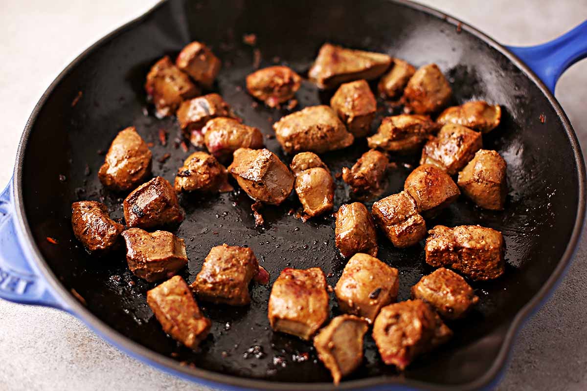 cast iron pan with fried liver chunks