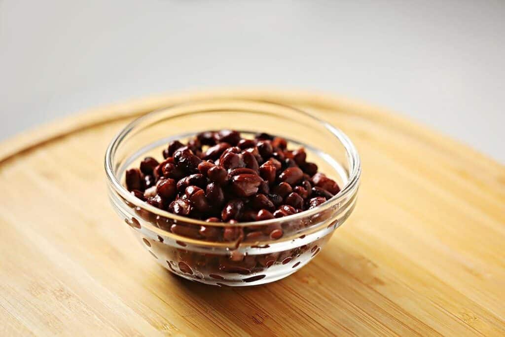 Glass dish filled with black beans. 
