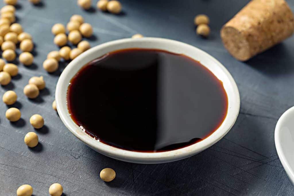 Small dish filled with dark with soy sauce .