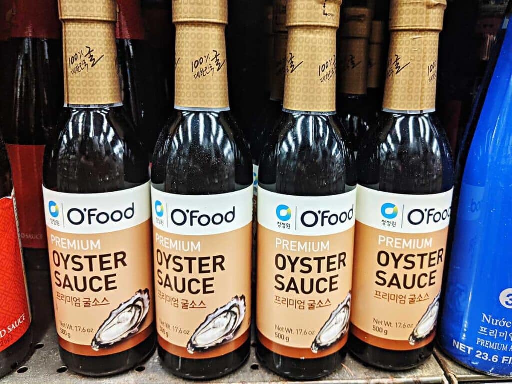 Grocery store shelf with bottles of Hoisin sauce. 