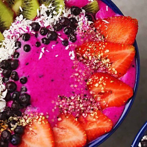 pink pitaya smoothie bowl topped with fresh fruits