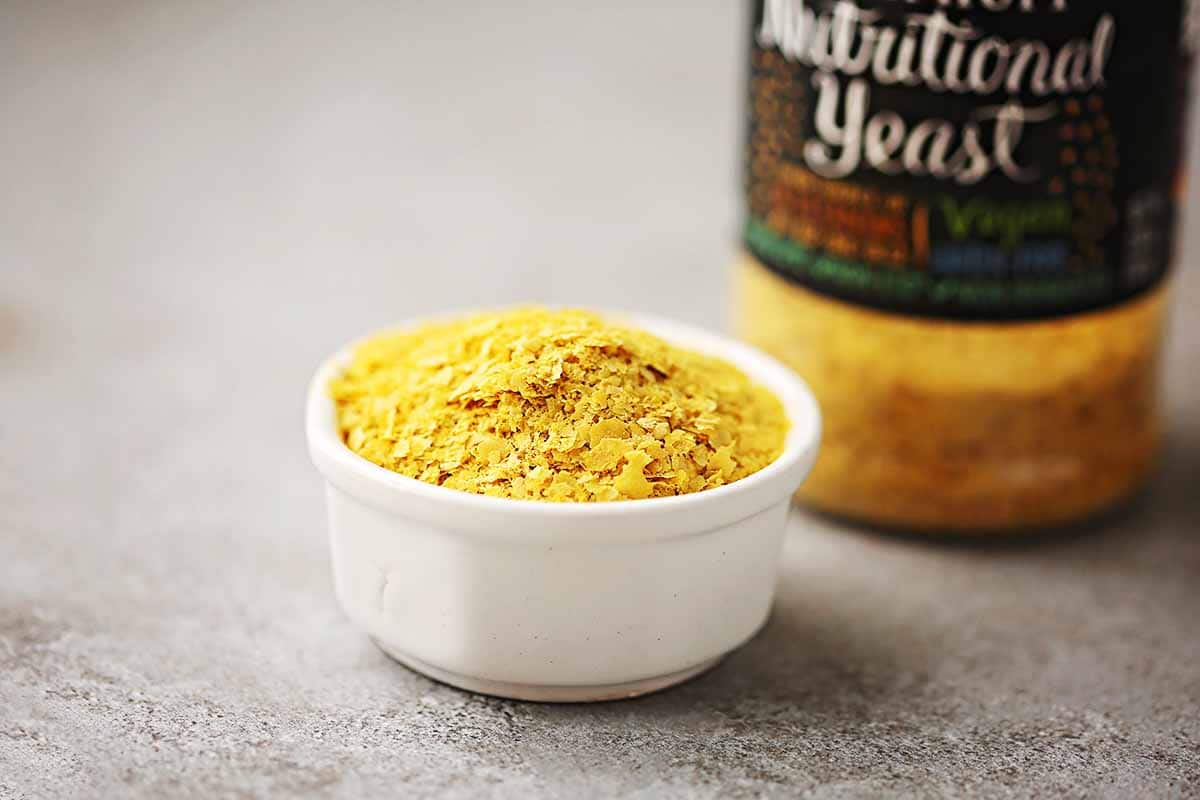 small dish filled with yellow nutritional yeast flakes  