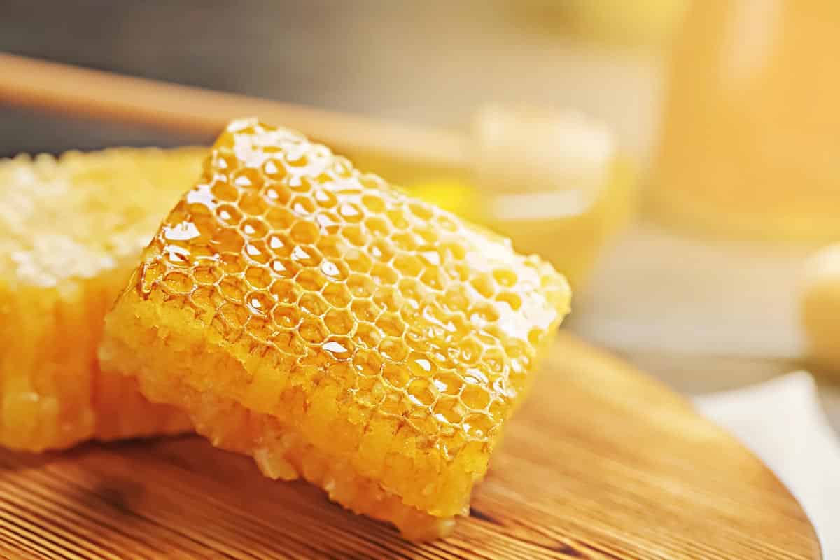 yellow honeycomb on top of wooden plate.