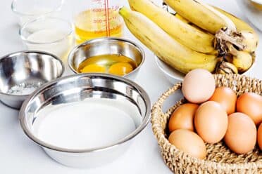 Tabletop with Ingredients including bananas, eggs, flour and butter
