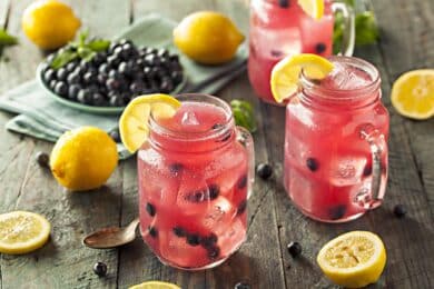 mason jars filled with lemonade and topped with fruits