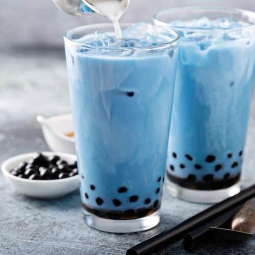 two glasses filled with blue-colored boba tea