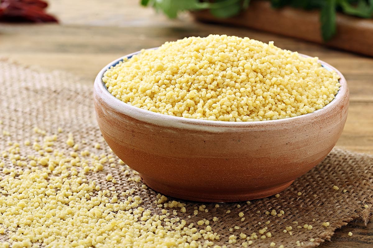 Bowl filled with uncooked couscous.