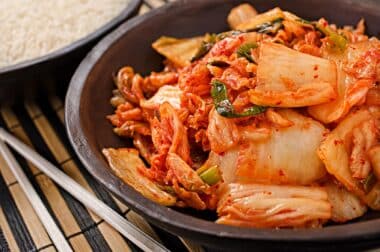 black bowl served with bright red kimchi.
