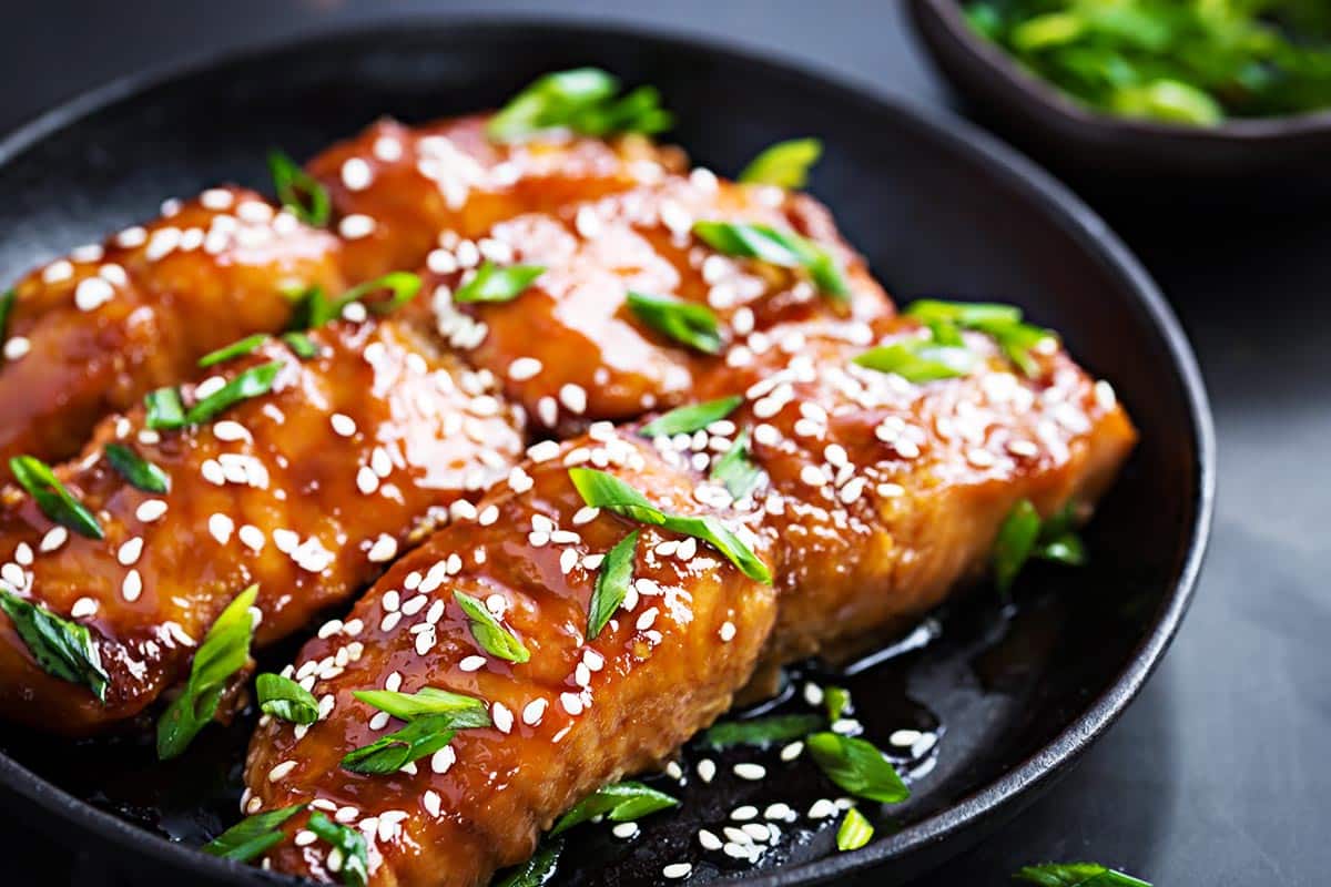 dish with cooked salmon topped with sweet soy glaze. 