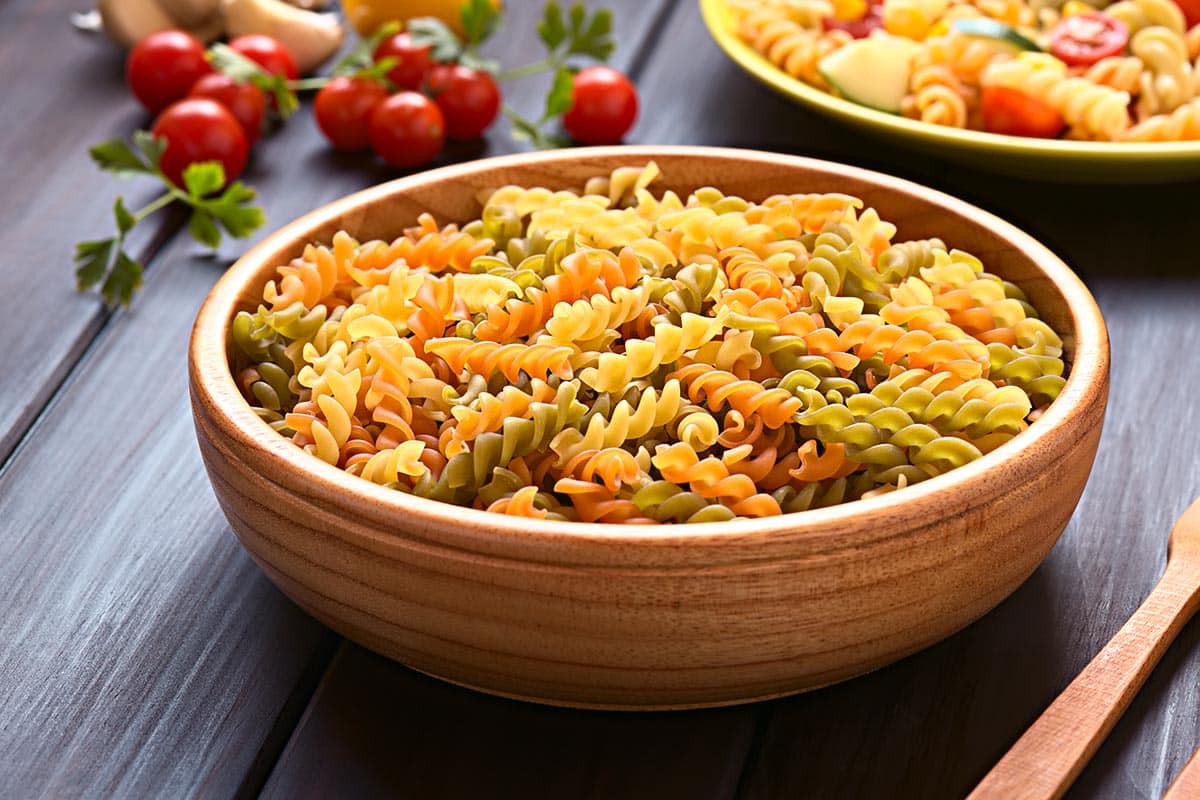 wooden bowl filled with rotini pasta