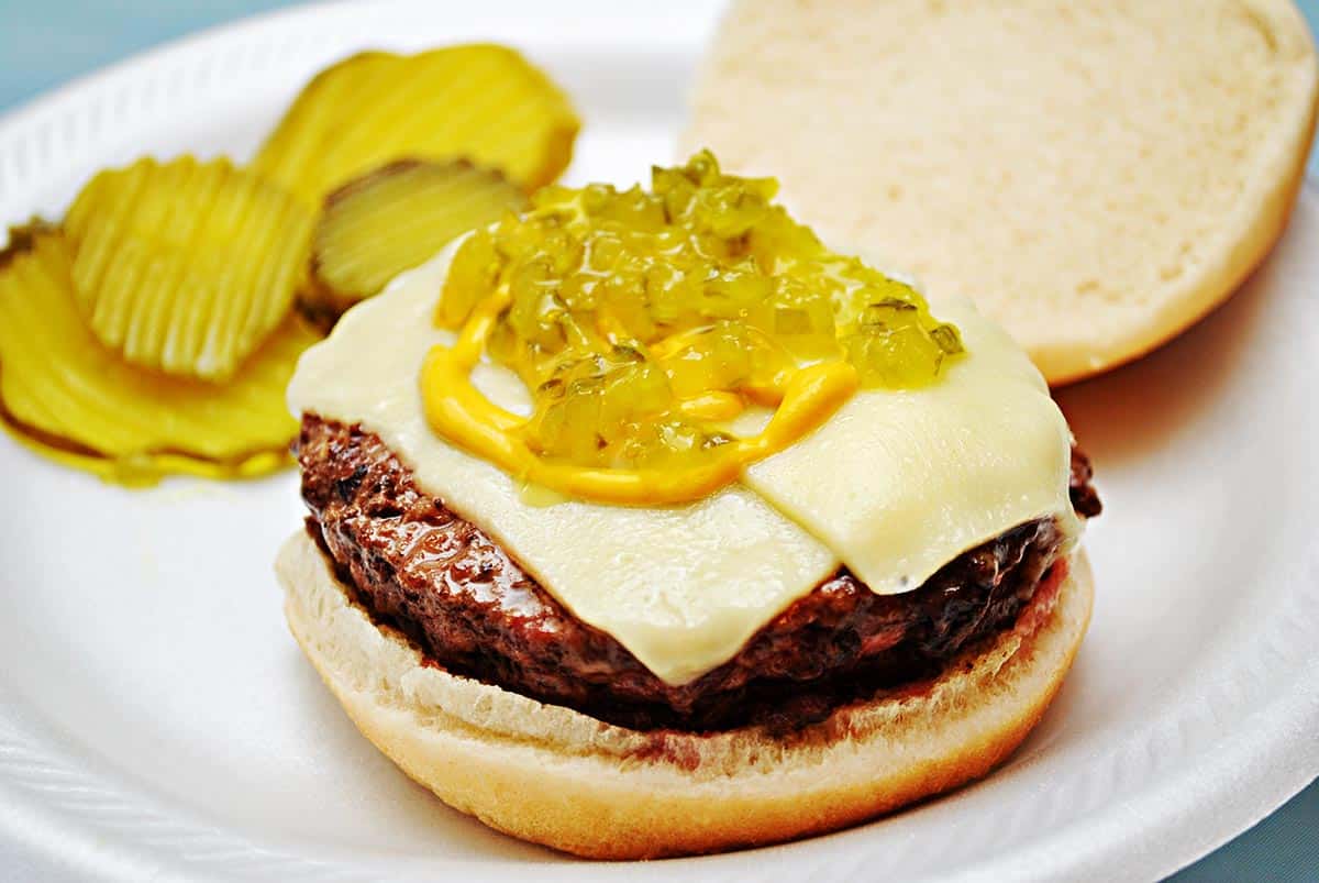 Cheeseburger topped with cheese and sweet pickle relish. 