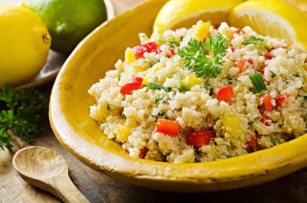 Yellow plate with cooked quinoa and vegetables. 