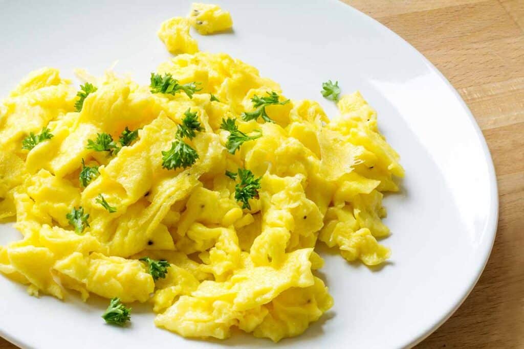 Plate with cooked scrambled eggs. 