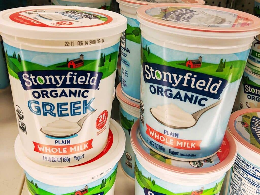 Two containers with greek yogurt at the store. 