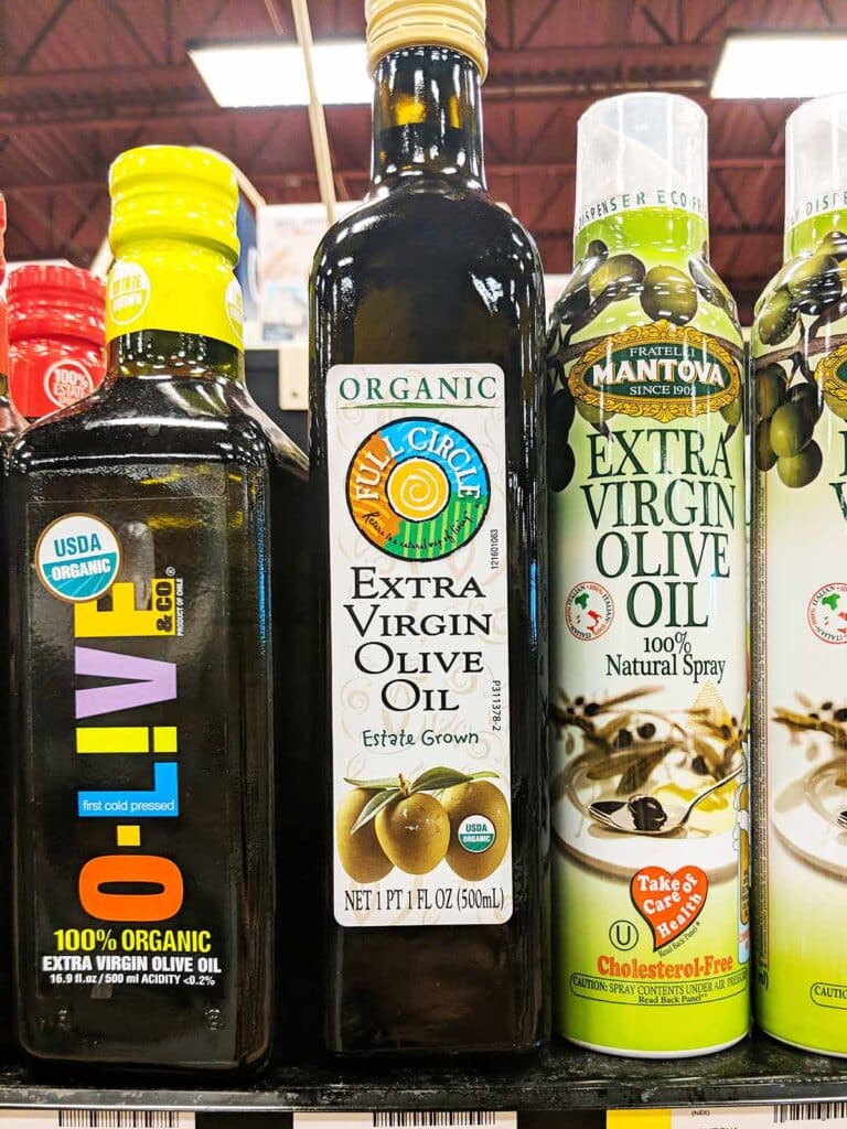 Bottles with varieties of vegetable oil lined up on the shelf. 