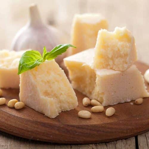 Crumbled pecorino cheese on top of round serving board.