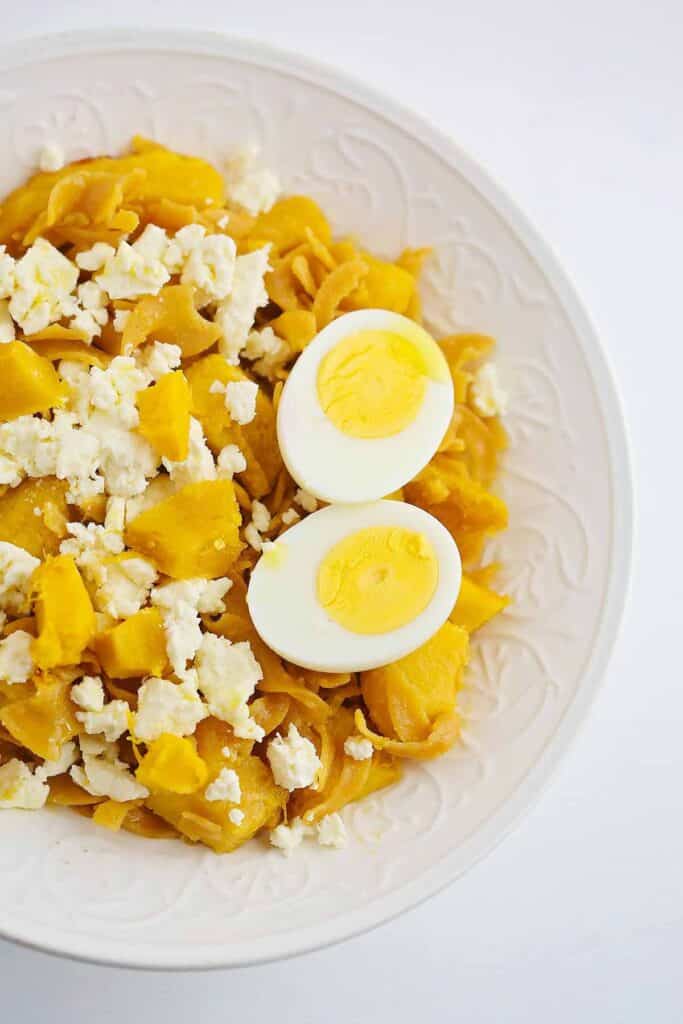 Yellow pasta served with boiled egg.