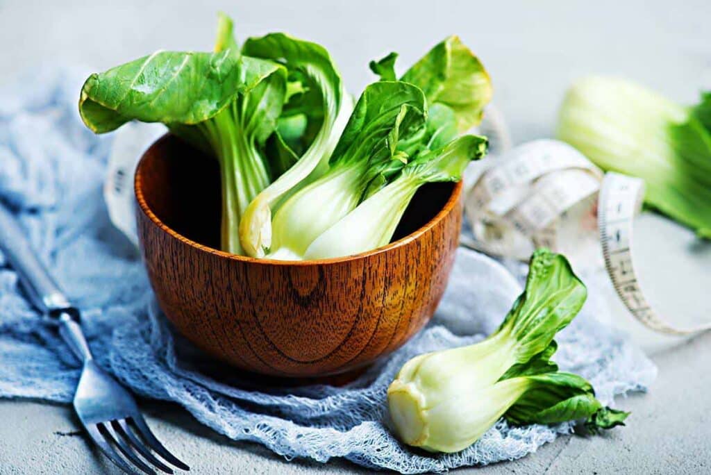 Wooden bowl with whole bok choy. 