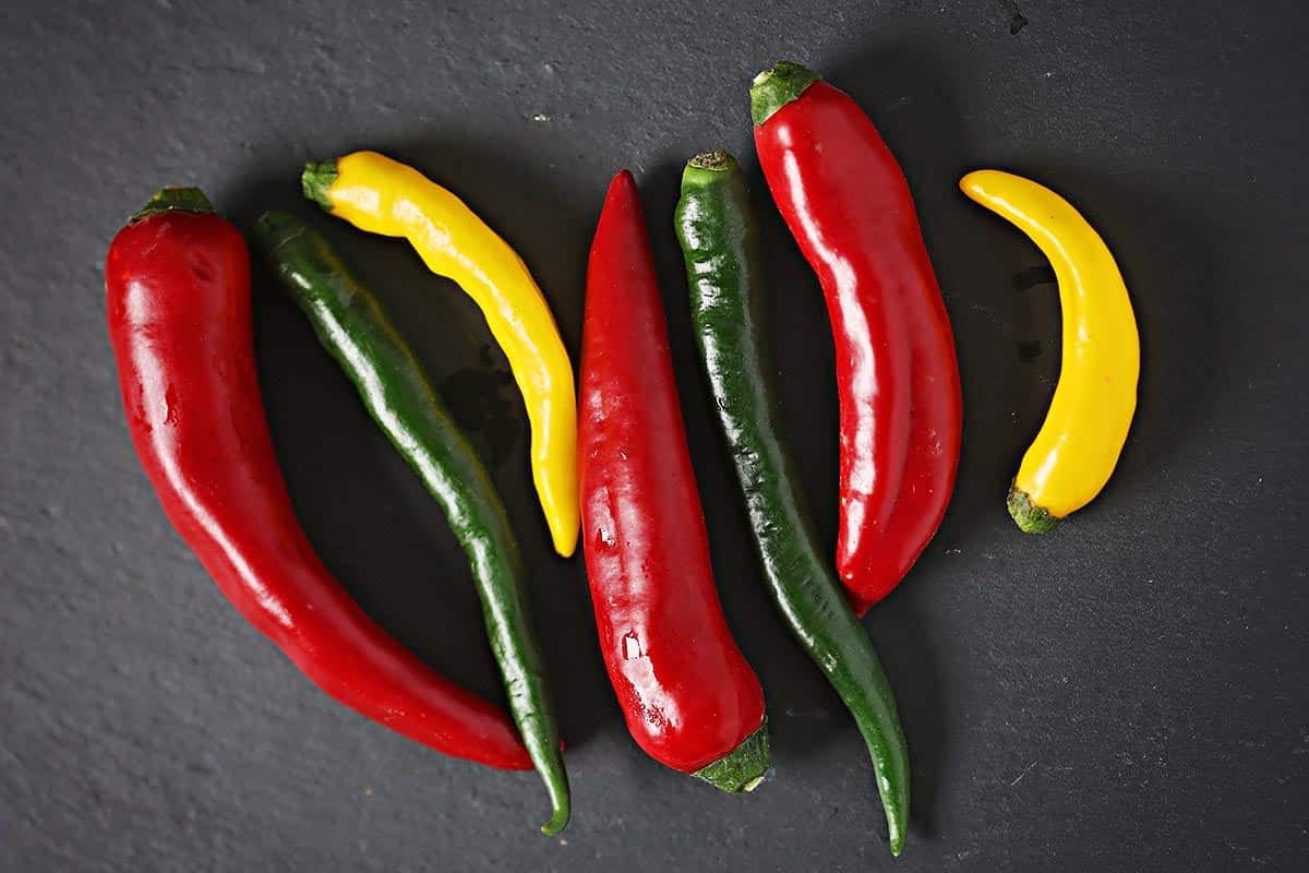 Black surface with different types of peppers. 