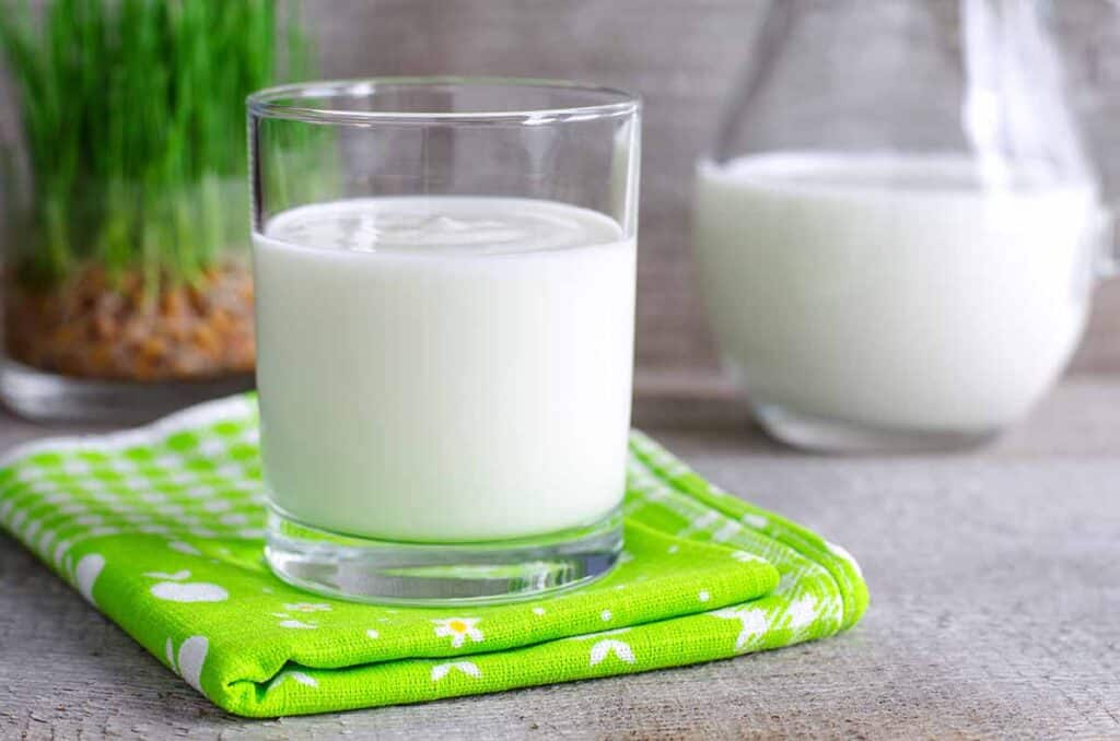Glass with soy milk on top of green napkin. 