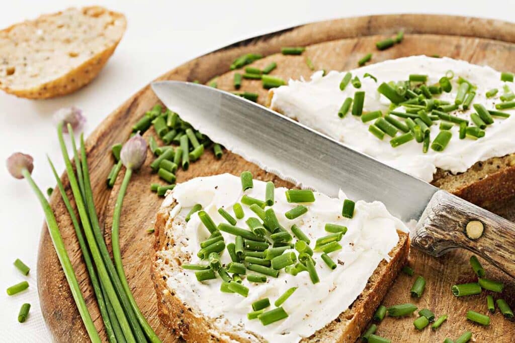 Slice of bread with Boursin cheese spread topped with herbs